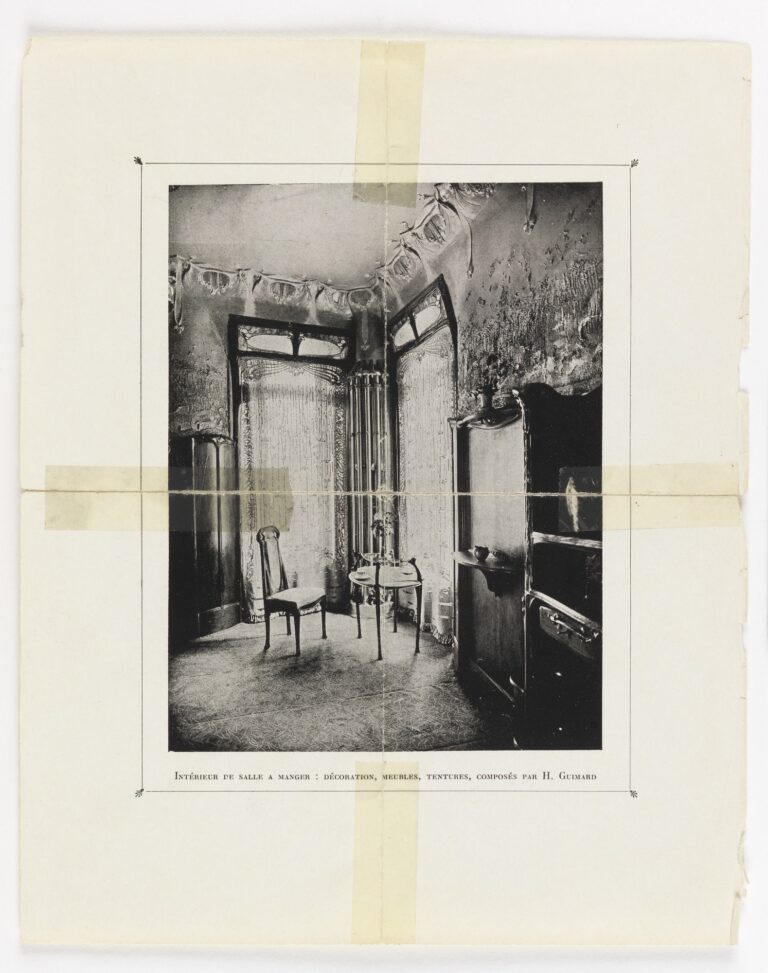 Archival black-and-white Art Nouveau dining room with curved partition-like frames, a small round table, slender chairs, and patterned surfaces